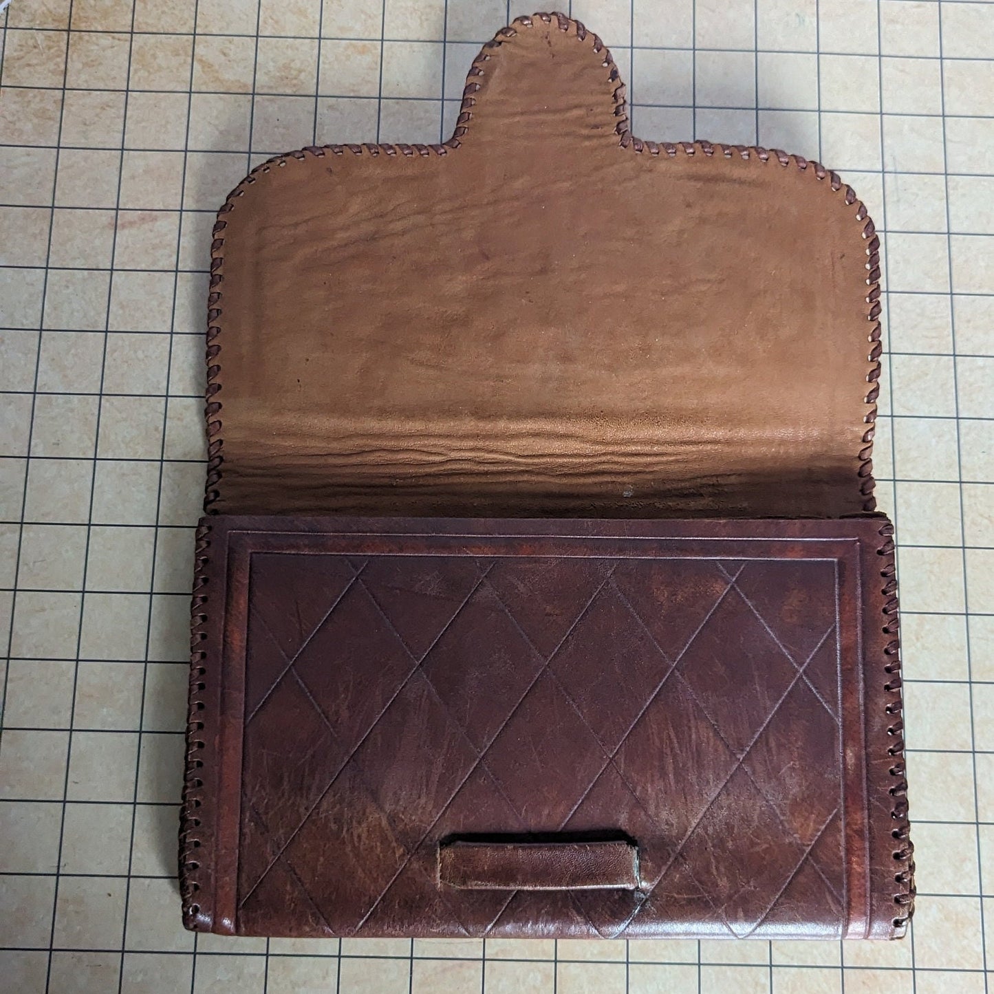 Vintage cowhide leather clutch, handmade, intricate design, strap on the back for easy carrying