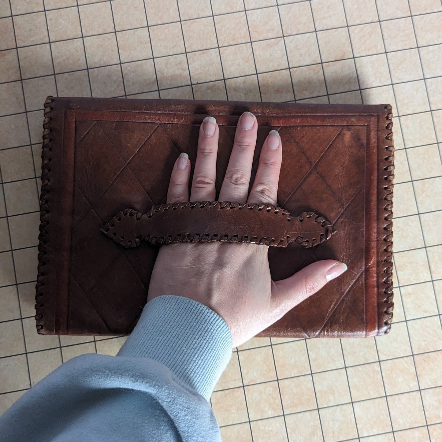 Vintage cowhide leather clutch, handmade, intricate design, strap on the back for easy carrying